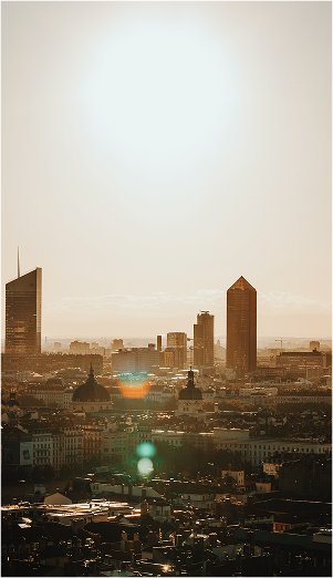 Vue urbaine au coucher du soleil avec bâtiments modernes.