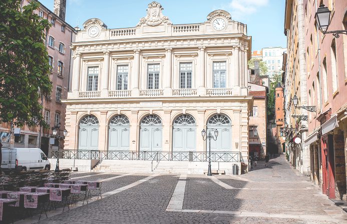 Une rue calme avec un bâtiment architectural élégant et historique.