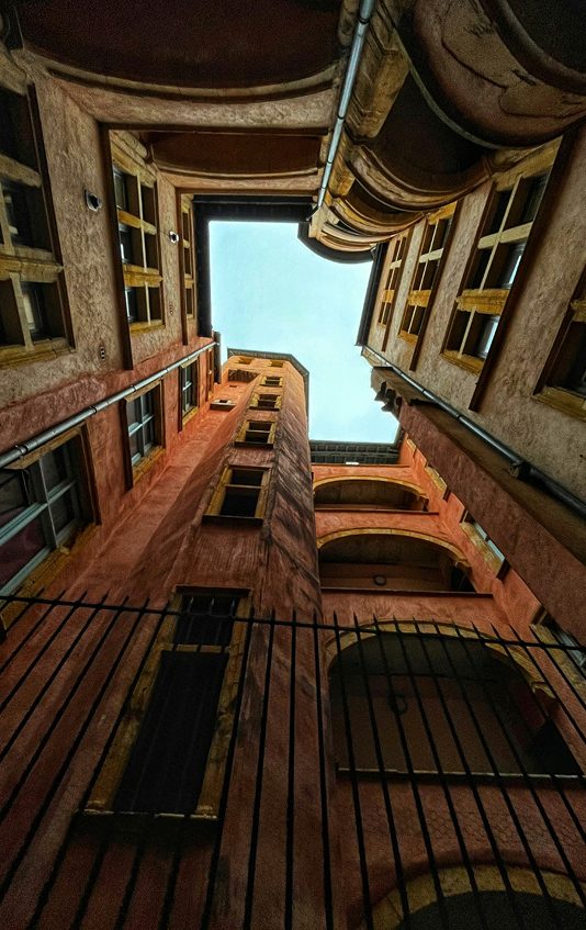 Vue plongeante d'une cour intérieure entre des bâtiments colorés.