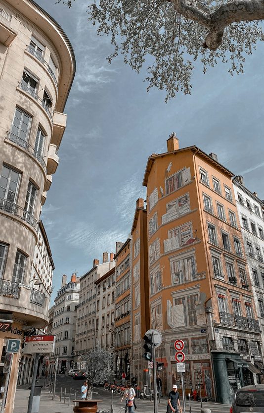 Mur coloré représentant des livres dans une rue dynamique.