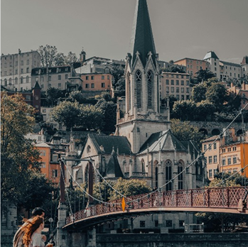 Une église surplombe une ville en bord de rivière.