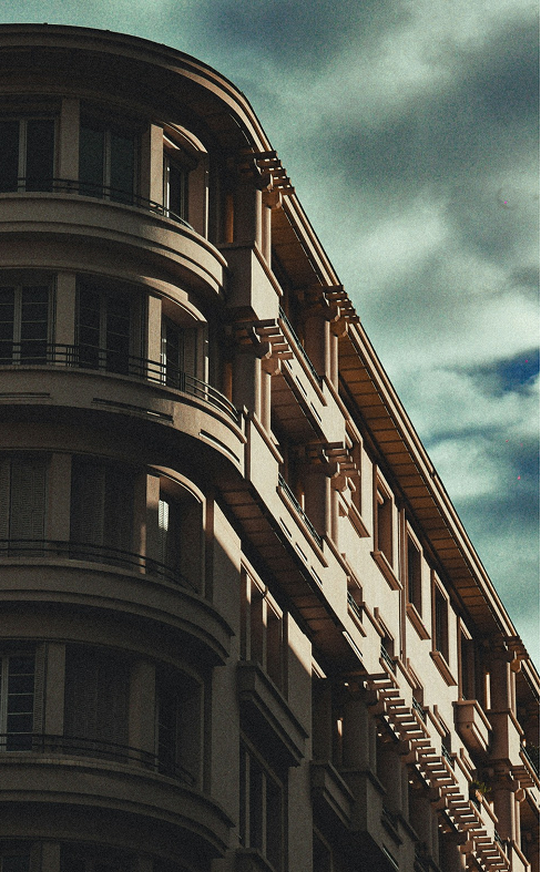 Immeuble aux lignes courbes sous un ciel nuageux.