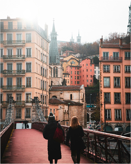 Deux personnes se promènent sur un pont urbain pittoresque.